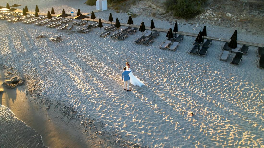 Drone view of a couple walking along a beach