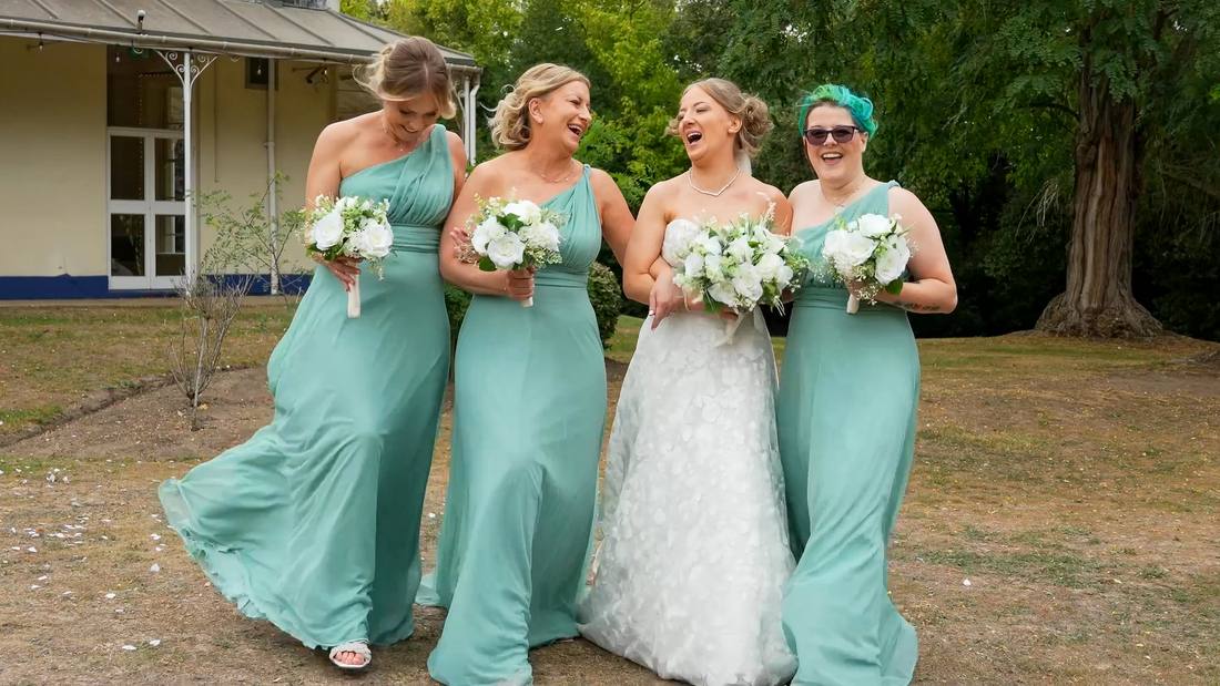 A bride laughing with her bridesmaids